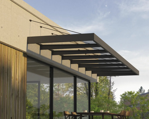 Toit de terrasse moderne en verre et métal sombre monté sur une façade avec revêtement en bois au dessus de la terrasse avec sièges.