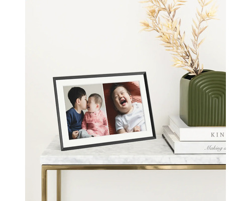 Schwarzer Bilderrahmen mit Fotos auf einem Tisch