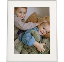 Cadre photo avec passe-partout et une photo de deux enfants souriants avec une peluche.