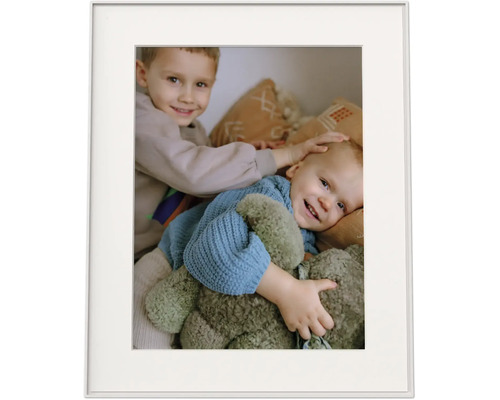 Cadre photo avec passe-partout et une photo de deux enfants souriants avec une peluche.