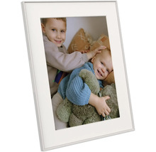 Cadre photo blanc avec passe-partout, présenté de biais, contenant une photo de deux enfants souriants avec un ours en peluche.