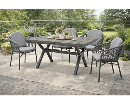 Table de jardin avec quatre chaises sur une terrasse avec un tapis gris