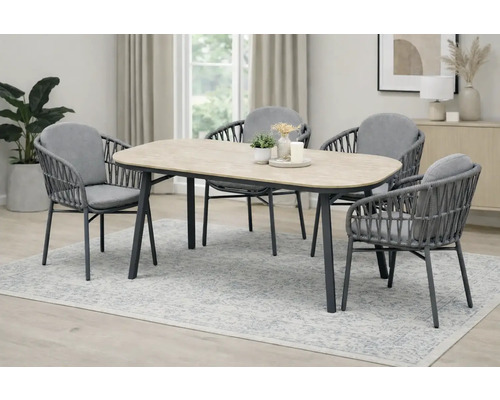 Ensemble de salle à manger avec quatre chaises et une table imitation bois dans une pièce lumineuse.