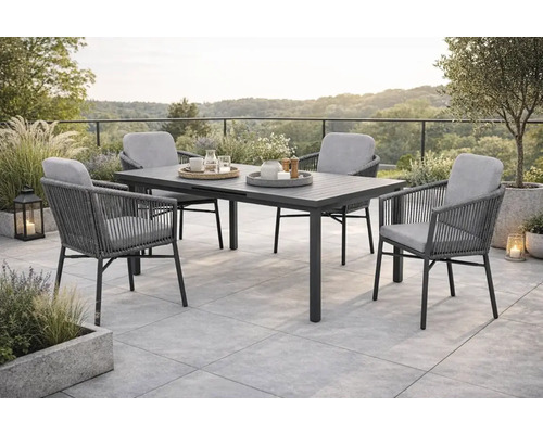 Scène de jardin avec table à manger et quatre chaises sur une terrasse.