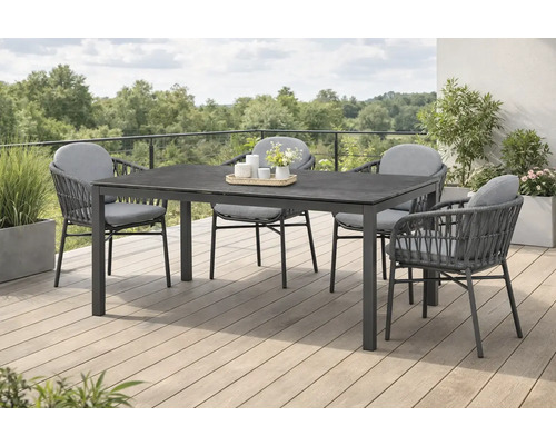 Table de jardin avec quatre chaises sur une terrasse avec plantes