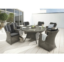 Scène de jardin avec une table à manger ronde en rotin et six fauteuils assortis avec coussins sur une terrasse.