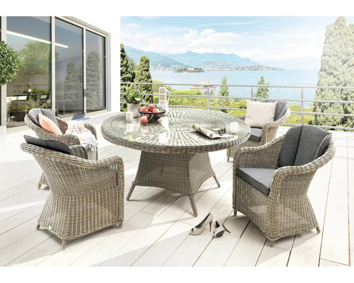 Terrasse avec table à manger, fauteuils en rotin et vue sur un lac