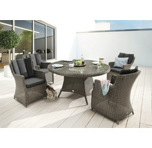 Scène de jardin avec table à manger ronde et quatre fauteuils en osier à l'extérieur