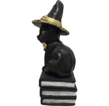 Figurine décorative de chat noir avec chapeau de sorcière sur une pile de livres