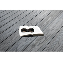 Livre et lunettes de soleil sur des lames de terrasse grises