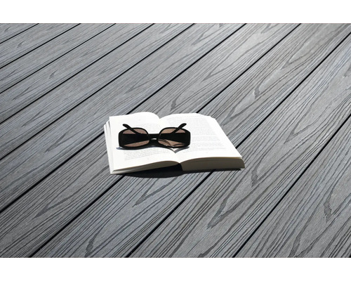 Livre et lunettes de soleil sur des lames de terrasse grises