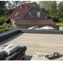 Grande terrasse en bois avec lames de terrasse et maison en arrière-plan