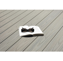 Livre et lunettes de soleil sur une terrasse en bois