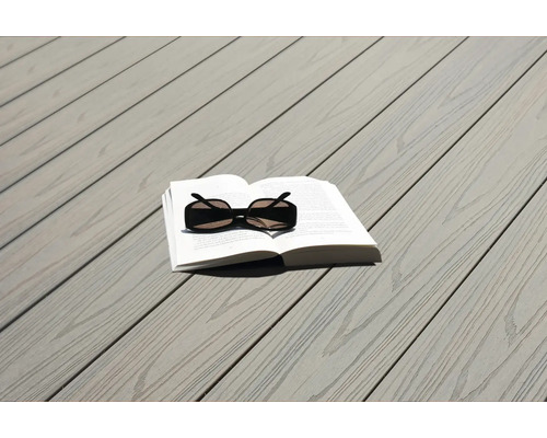 Livre et lunettes de soleil sur une terrasse en bois