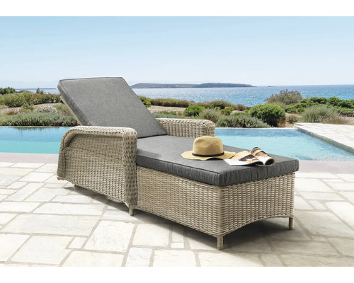 Gartenliege aus Rattan mit Auflage, Hut und Zeitschrift am Pool