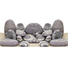 Dekorative Steine mit Streifenmuster auf Sand