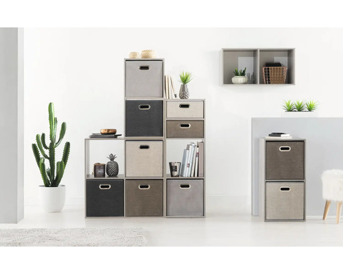 Étagère avec plusieurs compartiments et différentes boîtes de rangement dans une pièce lumineuse.