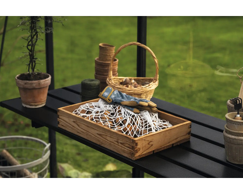 Scène de jardinage avec une caisse en bois, des gants de jardinage, des paniers de plantation et des outils de jardin sur une table