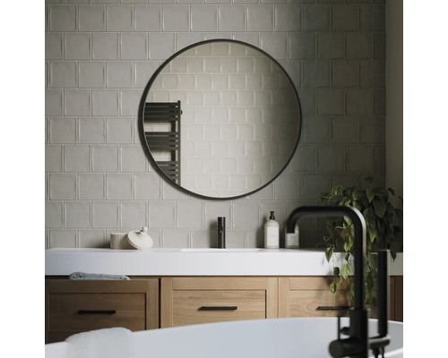 Salle de bain moderne avec meuble-lavabo, miroir rond et carrelage