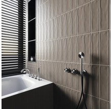 Salle de bains moderne avec baignoire, robinetterie, étagères et carreaux muraux allongés