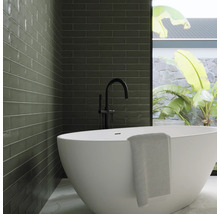 Modernes Badezimmer mit grünen Fliesen, freistehender Badewanne und schwarzer Armatur