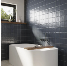 Salle de bain avec baignoire et carrelage mural