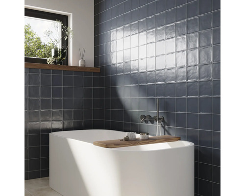 Salle de bain avec baignoire et carrelage mural