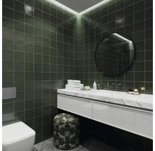 Salle de bain moderne avec carrelage vert, meuble-lavabo avec dessus en marbre, miroir rond et toilettes