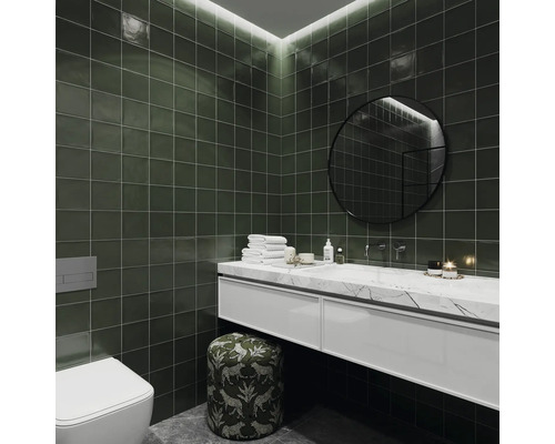 Salle de bain moderne avec carrelage vert, meuble-lavabo avec dessus en marbre, miroir rond et toilettes
