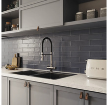 Scène de cuisine avec évier, robinet, carrelage et ustensiles de cuisine