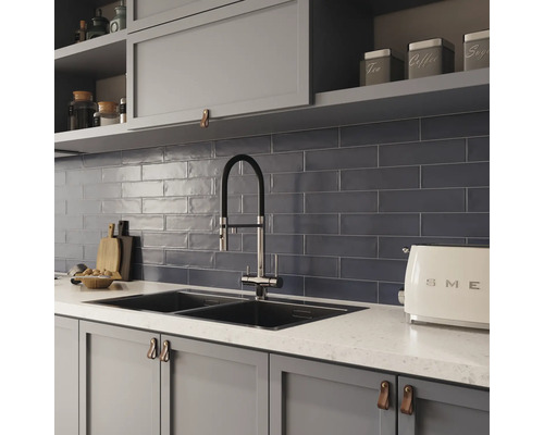 Scène de cuisine avec évier, robinet, carrelage et ustensiles de cuisine