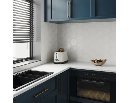 Cuisine moderne avec évier, grille-pain, four et carreaux muraux hexagonaux.