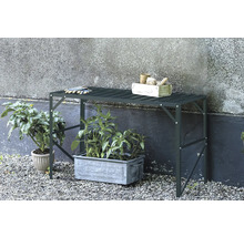 Table de jardin avec plantes, outils de jardinage et gants à l'extérieur