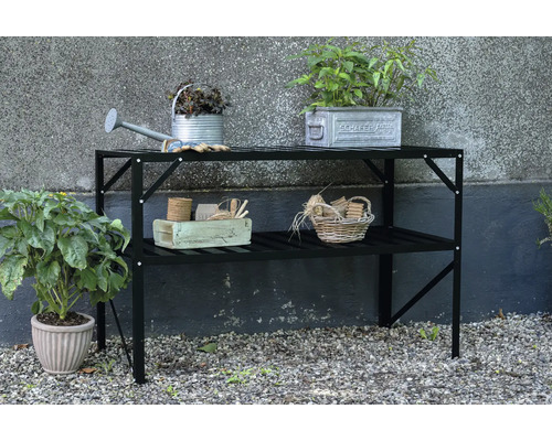 Table de jardin avec deux étagères et accessoires de jardin tels qu'un arrosoir et des plantes