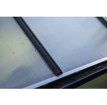 Gros plan d'une plaque de polycarbonate transparente avec des profilés noirs