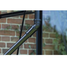 Gros plan d'un tube métallique noir avec des éléments de raccordement sur une serre.