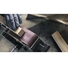 Gros plan d'une ponceuse à bande travaillant une pièce