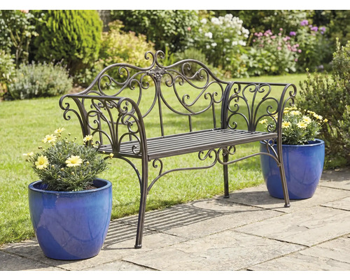 Banc de jardin en métal orné avec pots de fleurs sur une terrasse de jardin