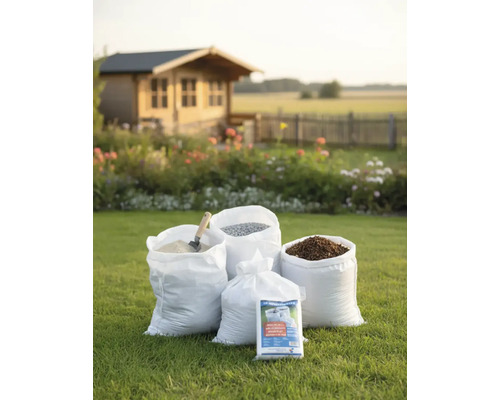 Divers matériaux en sacs dans le jardin, dont du sable, du gravier et du paillis