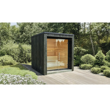 Sauna de jardin moderne de forme cubique avec façade en bois foncé et grande paroi vitrée sur une terrasse en bois.