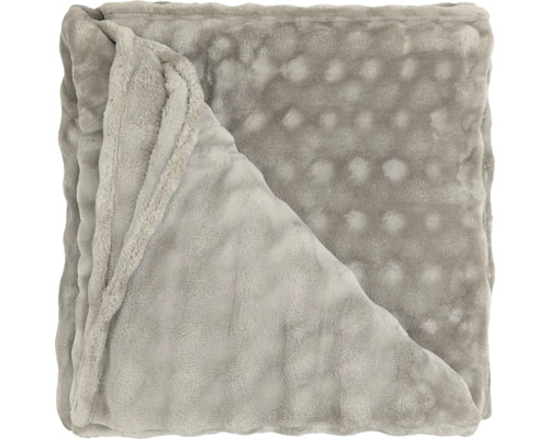Gefaltete, weiche Wohndecke mit Noppenstruktur aus Polyester.