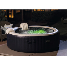 Jacuzzi gonflable avec appuie-tête et eau illuminée en couleur dans le jardin.