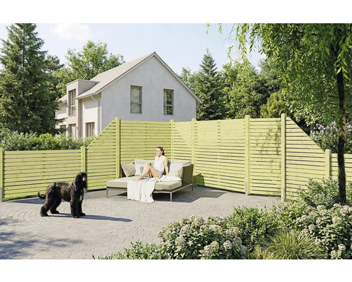 Clôture brise-vue en bois à lattes horizontales sur une terrasse pavée avec mobilier de jardin et un chien.