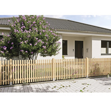 Vorgartenzaun als Lattenzaun aus Holz vor einem modernen Wohnhaus mit einem blühenden Strauch auf einem gepflasterten Grundstück.