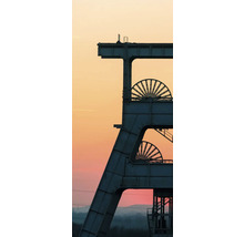 Chevalement industriel d une mine avec deux molettes devant un vaste ciel de soirée.