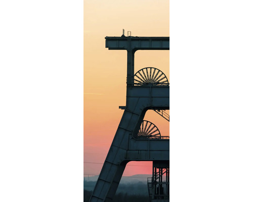 Chevalement industriel d une mine avec deux molettes devant un vaste ciel de soirée.