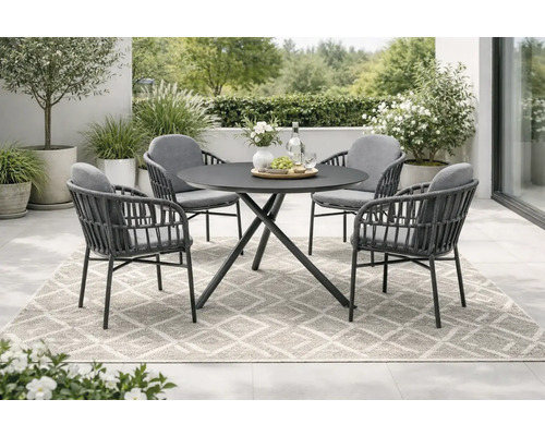 Scène de jardin avec une table ronde et quatre chaises sur un tapis à motifs