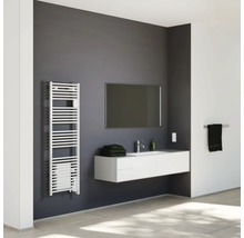 Salle de bains moderne et lumineuse avec radiateur sèche-serviettes, meuble sous-vasque suspendu, miroir et carrelage.