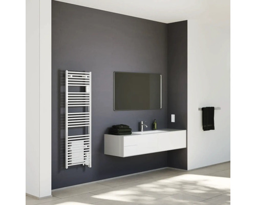 Salle de bains moderne et lumineuse avec radiateur sèche-serviettes, meuble sous-vasque suspendu, miroir et carrelage.