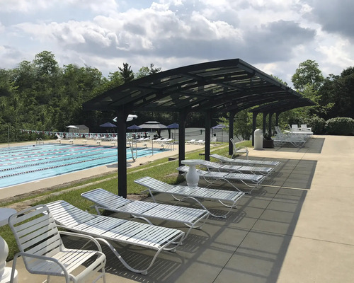 Schwimmbadbereich mit Liegestühlen und Überdachung.